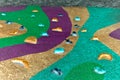 A climbing wall on a playground covered with a layer of snow broken as a child climbed on it. colored artificial stone handles pee