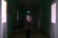 The child stands in the middle of the dark corridor of the hospital. Clinic fear and panic attacks. The boy is afraid of doctors. Royalty Free Stock Photo