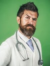 Clinic, healthcare, medicine and medical staff concept. Serious male doctor in white medical coat with stethoscope in Royalty Free Stock Photo