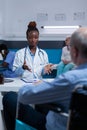 Clinic practitioner specialist discussing with retired man in wheelchair