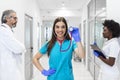 Clinic, profession, people, health care and medicine concept - happy group of medics or doctors at hospital corridor. Group of Royalty Free Stock Photo