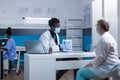 Clinic radiologist showing radiogram to sick elderly patient and recommending medical procedure