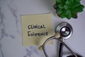 Clinical Evidence write on sticky notes isolated on Wooden Table