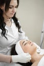 Clinical purity: in the beauty clinic, a cosmetologist cleanses a woman& x27;s face, providing her with a healthy and Royalty Free Stock Photo