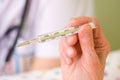 Clinical thermometer in elderly hands Royalty Free Stock Photo
