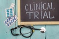 Clinical trial concept. Chalk board, stethoscope, pills