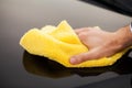 Clining car. Wiping panel of a luxury car with yellow microfiber, close-up view