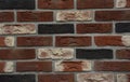 Clinker bricks background. A close-up of a clinker brick wall from dark red, white, orange and black bricks