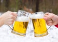 Clinking Beer glasses on winter forest background. Royalty Free Stock Photo