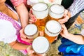 Clinking glasses with beer in Bavarian beer garden Royalty Free Stock Photo