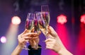 Clinking glasses of champagne in hands on bright lights background. Royalty Free Stock Photo