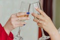 Clinking glasses of champagne in hands of two women. Royalty Free Stock Photo