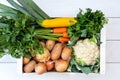 Clioseup of wooden box of fresh vegetables from farmers market on white painted wood table from above Royalty Free Stock Photo