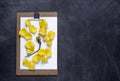 Clipboard with and aPetals of yellow rose on black background. V Royalty Free Stock Photo