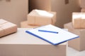 Clipboard, cardboard box and blurred stacked parcels on background Royalty Free Stock Photo