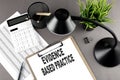 Clipboard ,chart and calculator, lamp and workspace accessories on a grey table. Top view , text EBP Evidence-based practice Royalty Free Stock Photo