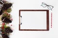 Clipboard christmas composition. fir branches, cones and christmas decorations on white background. flat lay top view.