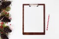 Clipboard christmas composition. fir branches, cones and christmas decorations on white background. flat lay top view.