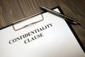 Clipboard with confidentiality clause and pen on desk Royalty Free Stock Photo