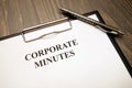 Clipboard with corporate minutes and pen on desk