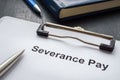 Clipboard with documents about severance pay and pen. Royalty Free Stock Photo