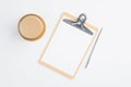 Clipboard with empty note and cup of coffee on white table. Flat lay, top view. Modern office desk concept Royalty Free Stock Photo