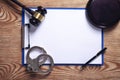 Clipboard, handcuffs, pen with judge gavel on wooden background Royalty Free Stock Photo