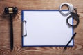 Clipboard, handcuffs, pen with judge gavel on wooden background Royalty Free Stock Photo