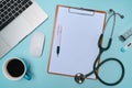 Clipboard, laptop, stethoscope, and coffee cup on doctor workspace. Royalty Free Stock Photo