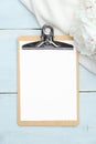 Clipboard mockup with blank sheet of paper and peonies on blue wooden table. Wedding checklist, planner, to do list