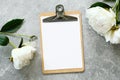 Clipboard mockup with peonies on concrete stone background. Flat lay, top view. Wedding planner, to do list, checklist concept Royalty Free Stock Photo