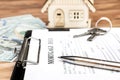 Clipboard with mortgage deed, keys, money and model of house on the table Royalty Free Stock Photo