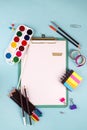 Clipboard and office or school supplies over blue background, flat lay. Back to school Royalty Free Stock Photo