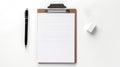 A clipboard with a paper, a pen and an eraser on a white background. The clipboard is brown and has a silver clip. The Royalty Free Stock Photo