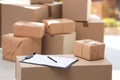 Clipboard, parcel with tag and blurred stacked boxes on background