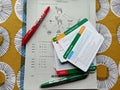 A clipboard with past exam questions, a set of revision cards and coloured pens for marking