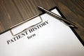 Clipboard with patient history form and pen on desk Royalty Free Stock Photo