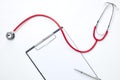 clipboard with red stethoscope and pen Royalty Free Stock Photo