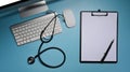 Clipboard, stethoscope and computer on blue background. Healthcare and medical. Royalty Free Stock Photo