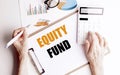 Clipboard with text equity fund on white desk with hands using calculator, pen, charts and glasses Royalty Free Stock Photo