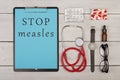 clipboard with text & x22;Stop measles& x22;, pills, stethoscope, eyeglasses and watch Royalty Free Stock Photo