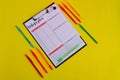 Clipboard with todays plan and pens on yellow background.