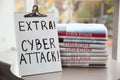 Clipboard with words EXTRA! CYBER ATTACK! and newspapers on table, closeup Royalty Free Stock Photo