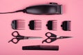Clipper and scissors with comb on a pink background, barber tools Royalty Free Stock Photo