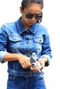 Clipping paths,woman in jeans suit and wearing sunglasses with the shooting range shot from a revolvers Royalty Free Stock Photo