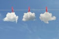 Clips for laundry hanging clouds on a string rope on blue sky Royalty Free Stock Photo