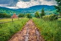 CloÃÂ³dy summer evening on Yasinya village with old country road, Ukraine, Europe Royalty Free Stock Photo