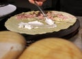 cloae up a hand holding spoon smearing cream on ham and mushroom crepe Royalty Free Stock Photo