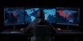 A cloaked individual sits before a computer, looking at a large screen that shows a world map and digital data, creating