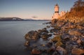 Cloch lighthouse in Scotland with long exposure of water across the rocky shore at sunset